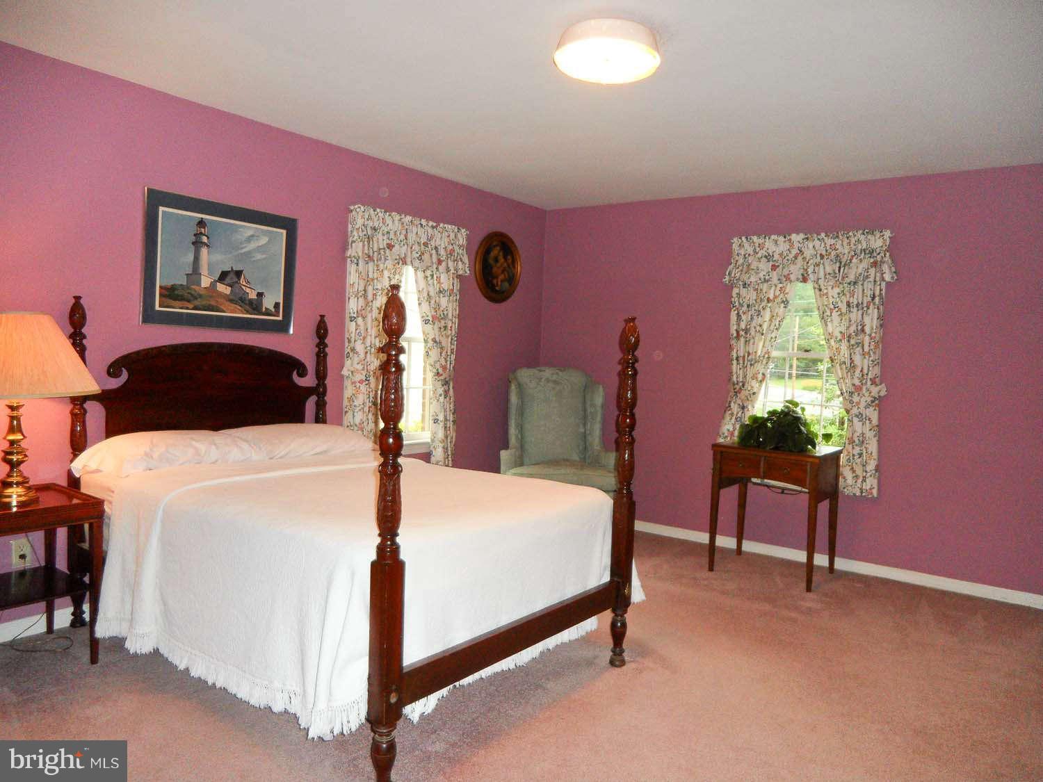 5908 Walhonding Road Bethesda, MD 20816 - Photo 14 of 26 a bedroom with a bed and a chandelier