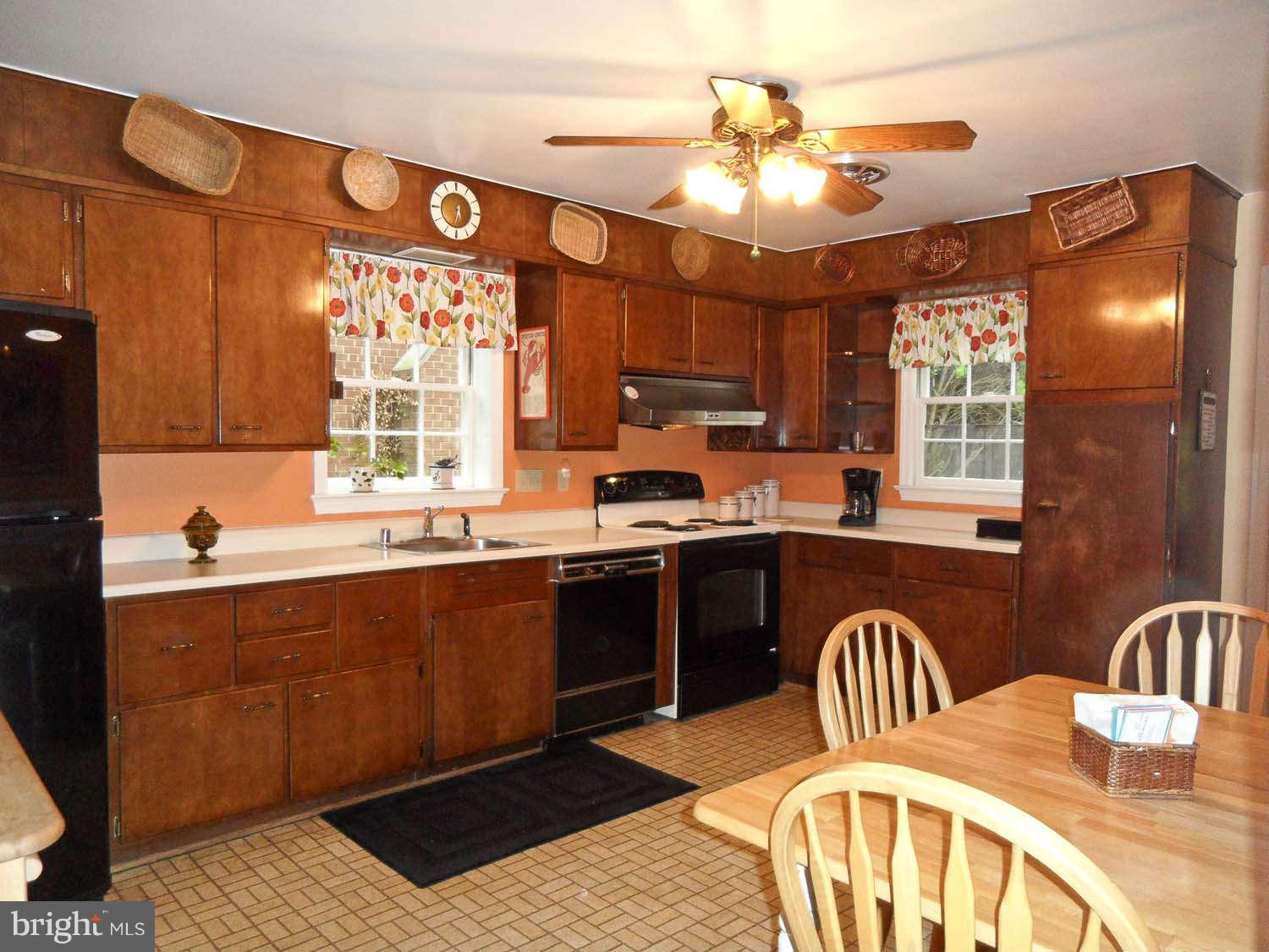 5908 Walhonding Road Bethesda, MD 20816 - Photo 7 of 26 a kitchen with stainless steel appliances granite countertop a stove a sink dishwasher a dining table and chairs with wooden floor
