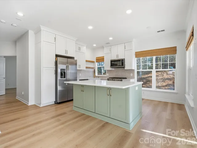 a kitchen with stainless steel appliances granite countertop a refrigerator sink and cabinets