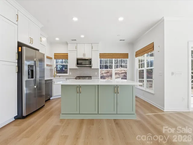 a kitchen with stainless steel appliances granite countertop a refrigerator a stove a sink and a microwave