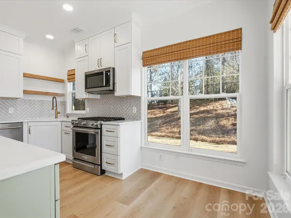 a kitchen with stainless steel appliances granite countertop a stove a refrigerator and a sink