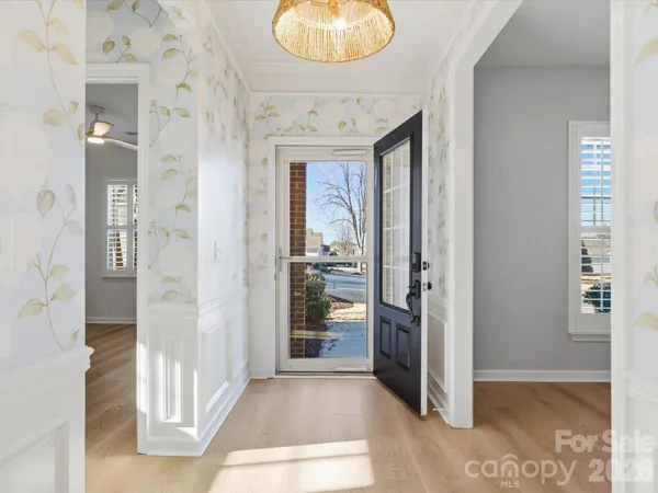 view of hall way with wooden floor and a bathroom