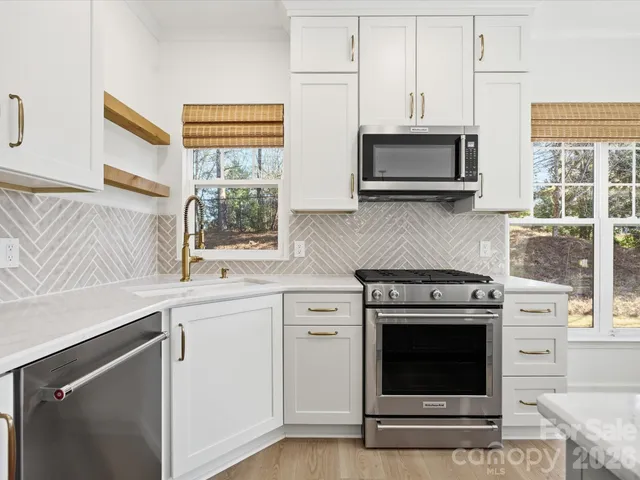 a kitchen with stainless steel appliances granite countertop a stove and a refrigerator