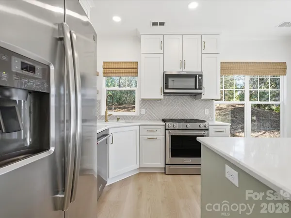 a kitchen with stainless steel appliances granite countertop a stove and a sink
