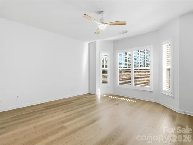 a view of empty room with window and ceiling fan