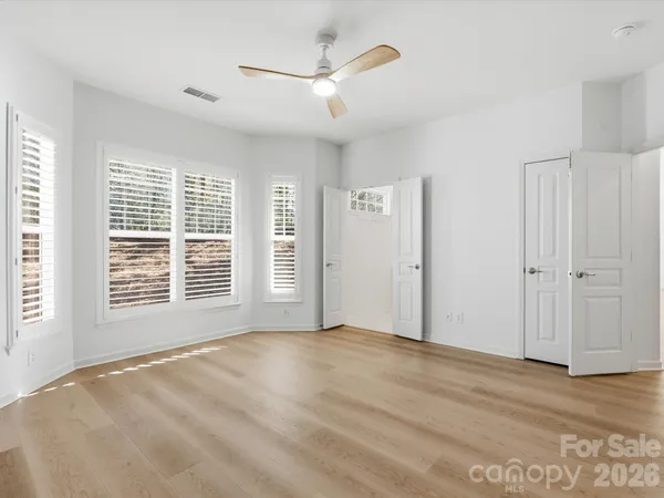 a spacious bedroom with a bed and a large window