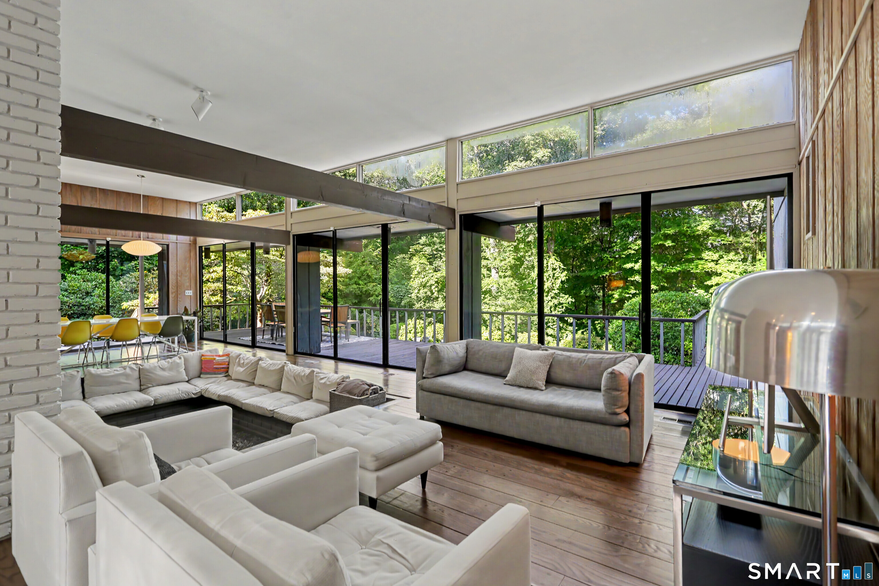 9 Autumn Ridge Road Weston, CT 06883 - Photo 5 of 40 Sliding doors from the living room and dining room open to the deck, creating a seamless indoor-outdoor flow.