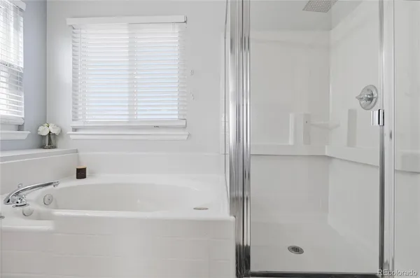 a en suite bathroom with a double vanity sink a mirror and a bathtub