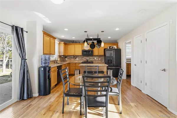 a view of kitchen with stainless steel appliances refrigerator oven dining table and chairs
