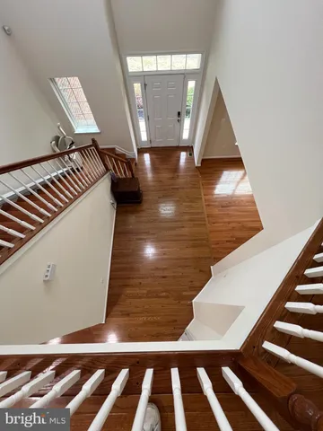 a kitchen with stainless steel appliances kitchen island granite countertop a refrigerator a sink dishwasher a stove and a oven with wooden floor