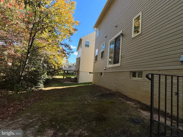 a view of a hallway with wooden floor and a living room