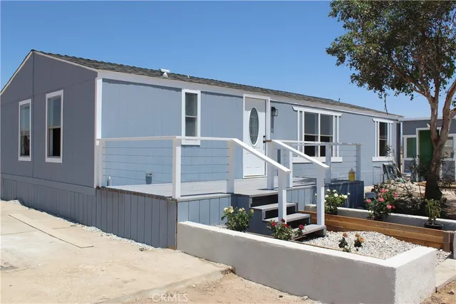 a view of a house with couches and wooden fence