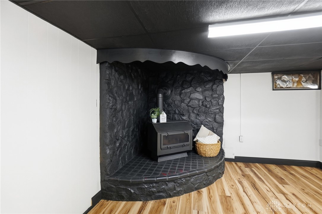 1628 Yorkshire Court Springfield, OH 45503 - Photo 30 of 47 Warm and inviting basement features a cozy wood-burning stove on a stone hearth.