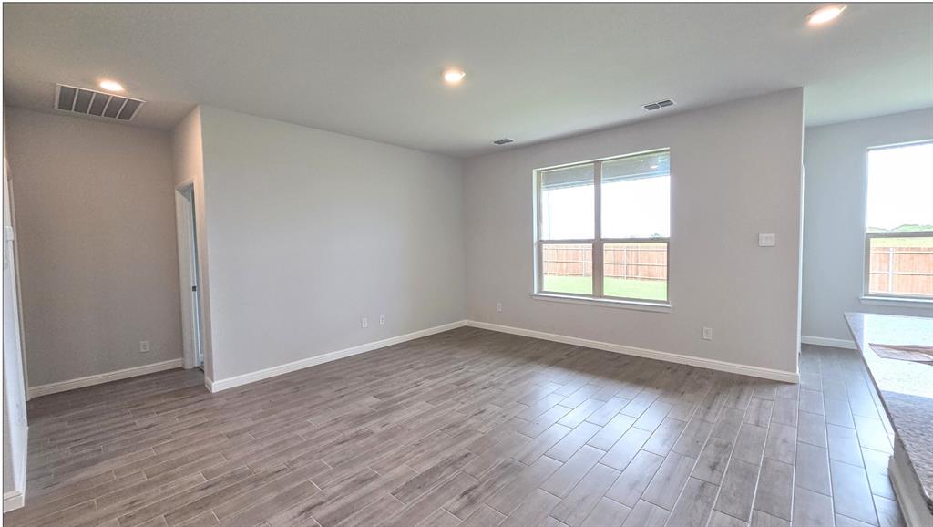 240 Kinley Street Grandview, TX 76050 - Photo 3 of 15 an empty room with wooden floor and windows