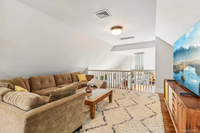 a living room with furniture a rug and white walls