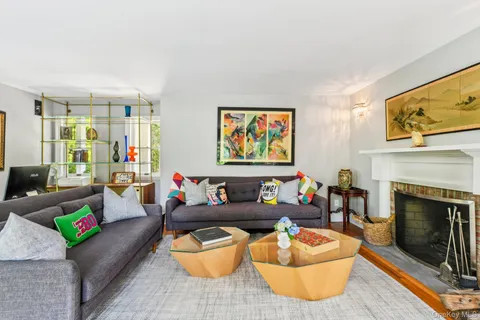 a living room with furniture a fireplace and wooden floor