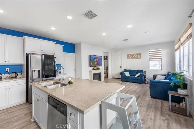 a view of kitchen with stainless steel appliances granite countertop sink microwave and wooden floor