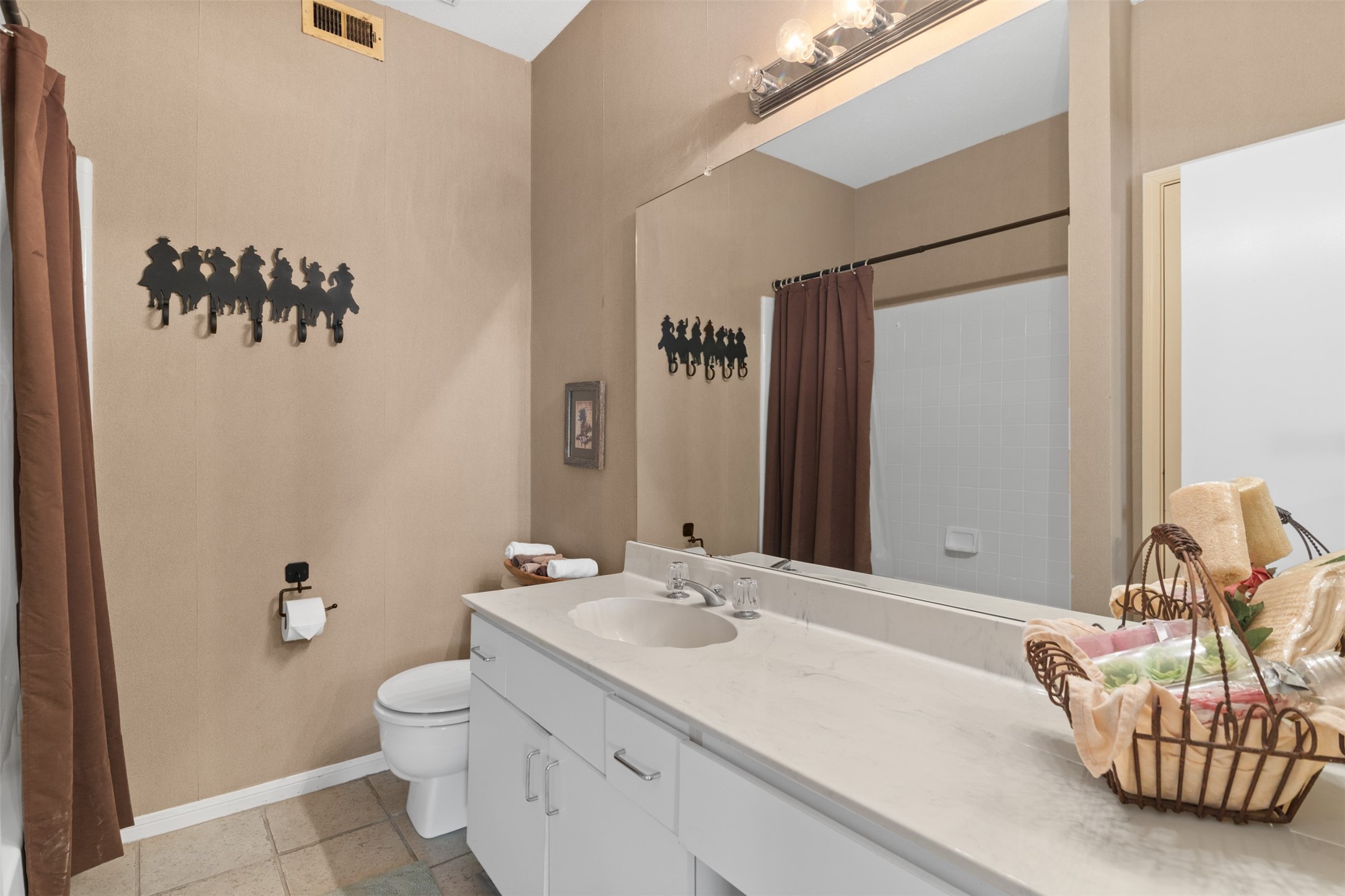 6000 Reims Road, Unit 2307 Houston, TX 77036 - Photo 19 of 26 This bathroom features a clean, modern design with a large mirror, white countertop, and cabinetry.