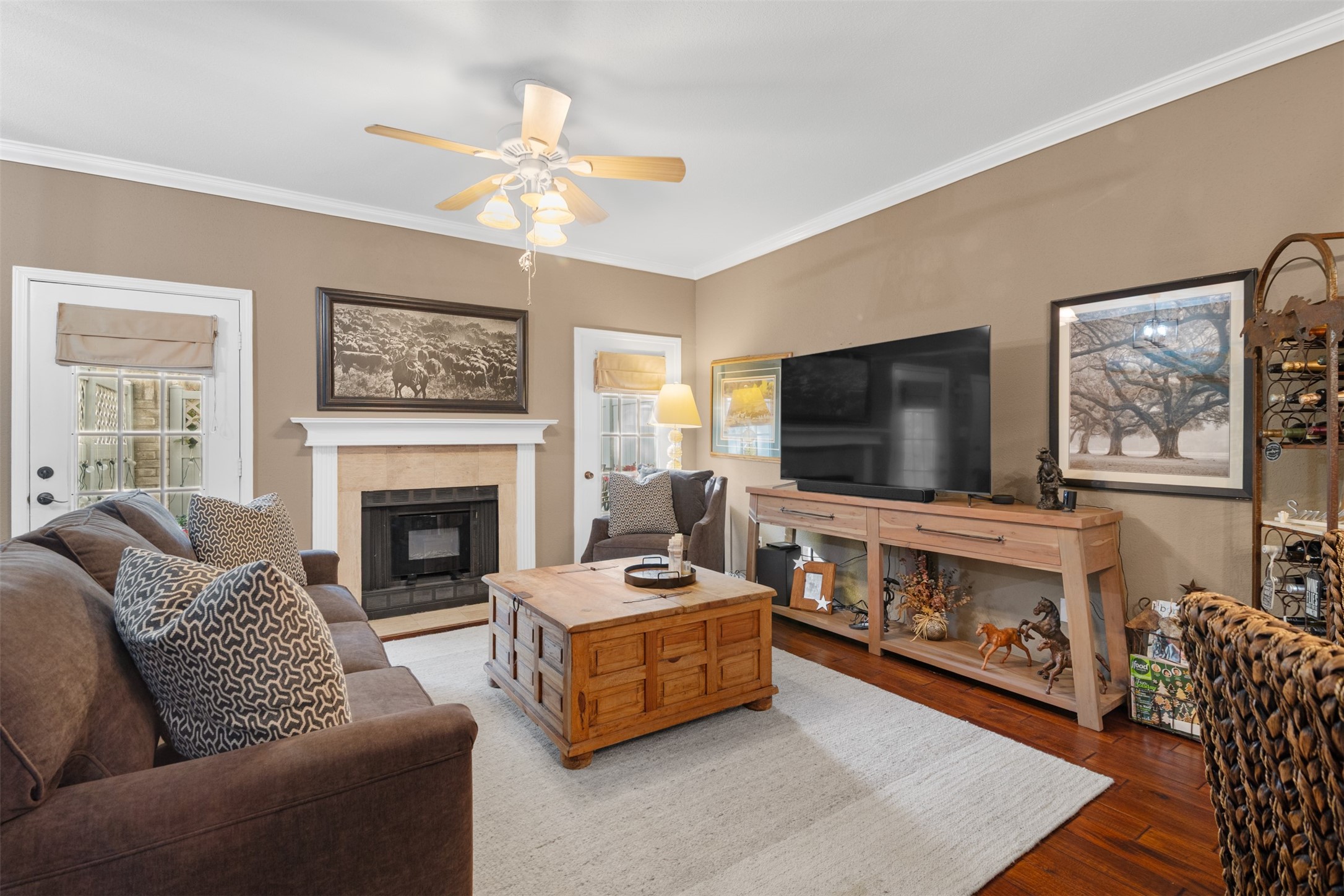 6000 Reims Road, Unit 2307 Houston, TX 77036 - Photo 3 of 26 Cozy living room with a warm color palette, featuring a fireplace, ceiling fan, and space for a large TV.