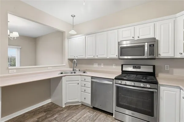 a kitchen with white cabinets stainless steel appliances and sink