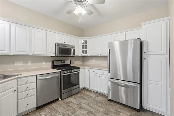 a kitchen with stainless steel appliances white cabinets and a refrigerator
