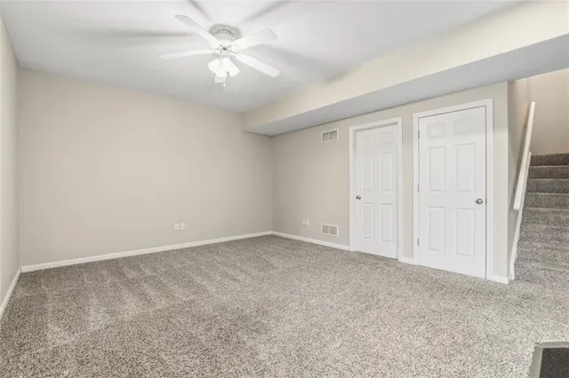 an empty room with a ceiling fan and a window