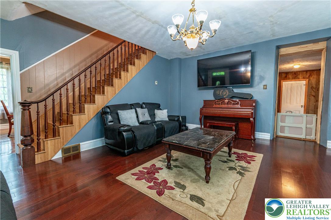 2485 Hieter Road Quakertown, PA 18951 - Photo 20 of 97 Rich hardwood flooring complements a grand staircase, setting a refined tone for this cozy living space.