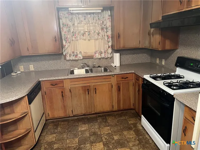 a kitchen with a sink stove and cabinets