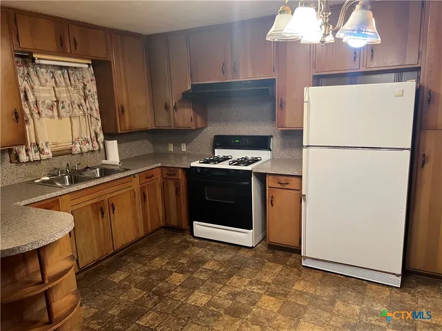 a kitchen with a stove a sink and a refrigerator