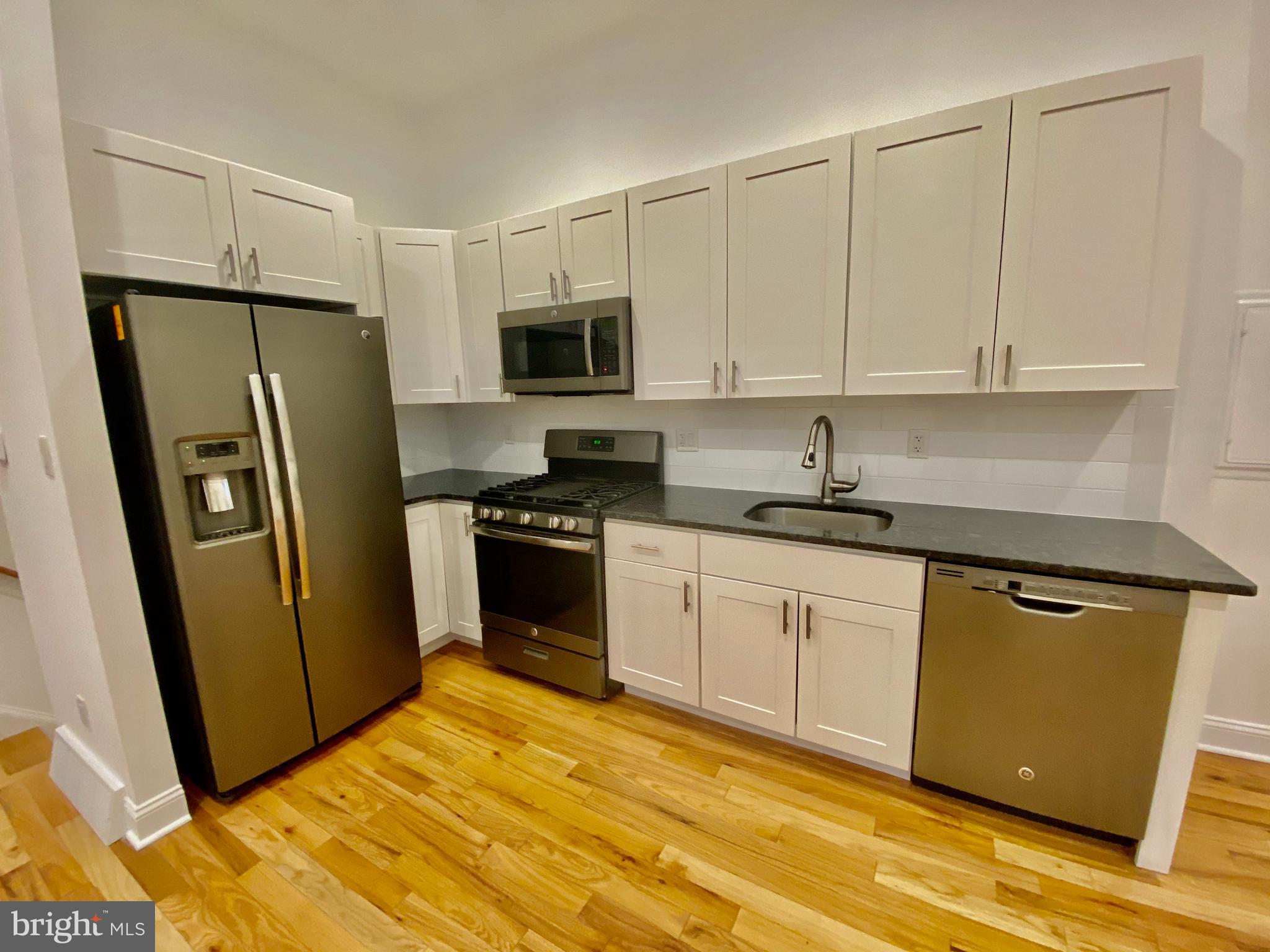 1640 Jackson Street Philadelphia, PA 19145 - Photo 7 of 27 a kitchen with stainless steel appliances a refrigerator sink and microwave