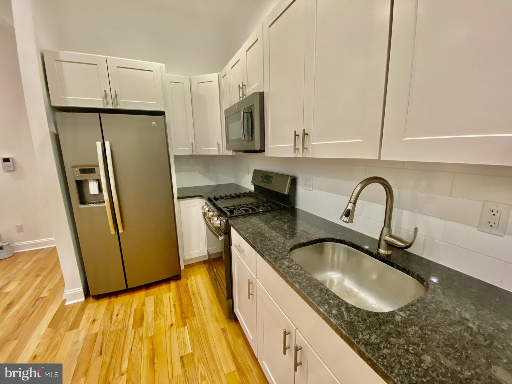 1640 Jackson Street Philadelphia, PA 19145 - Photo 8 of 27 a kitchen with granite countertop a sink stainless steel appliances and cabinets
