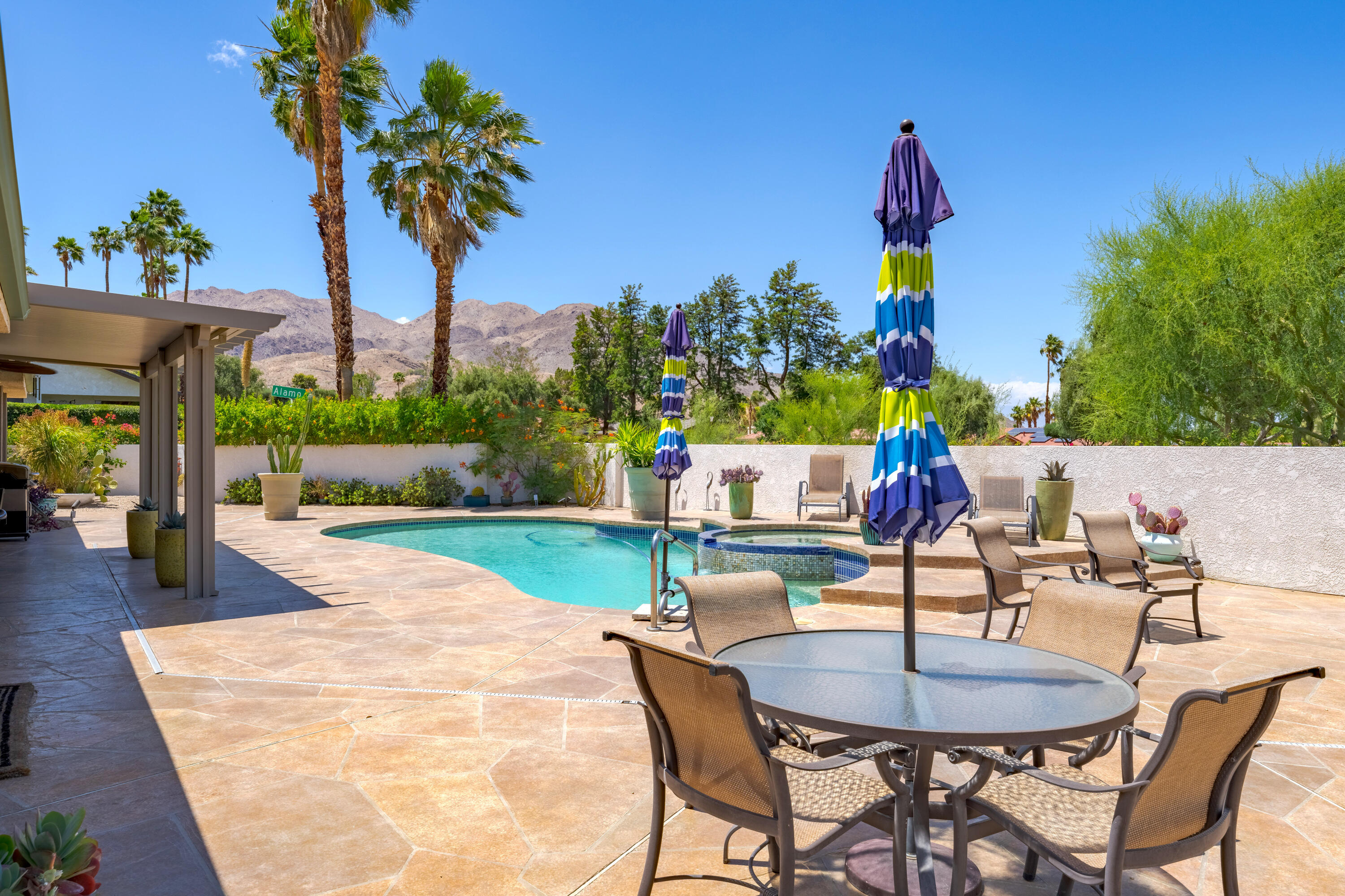 73005 Haystack Road Palm Desert, CA 92260 - Photo 1 of 45 a swimming pool with outdoor seating and potted plants