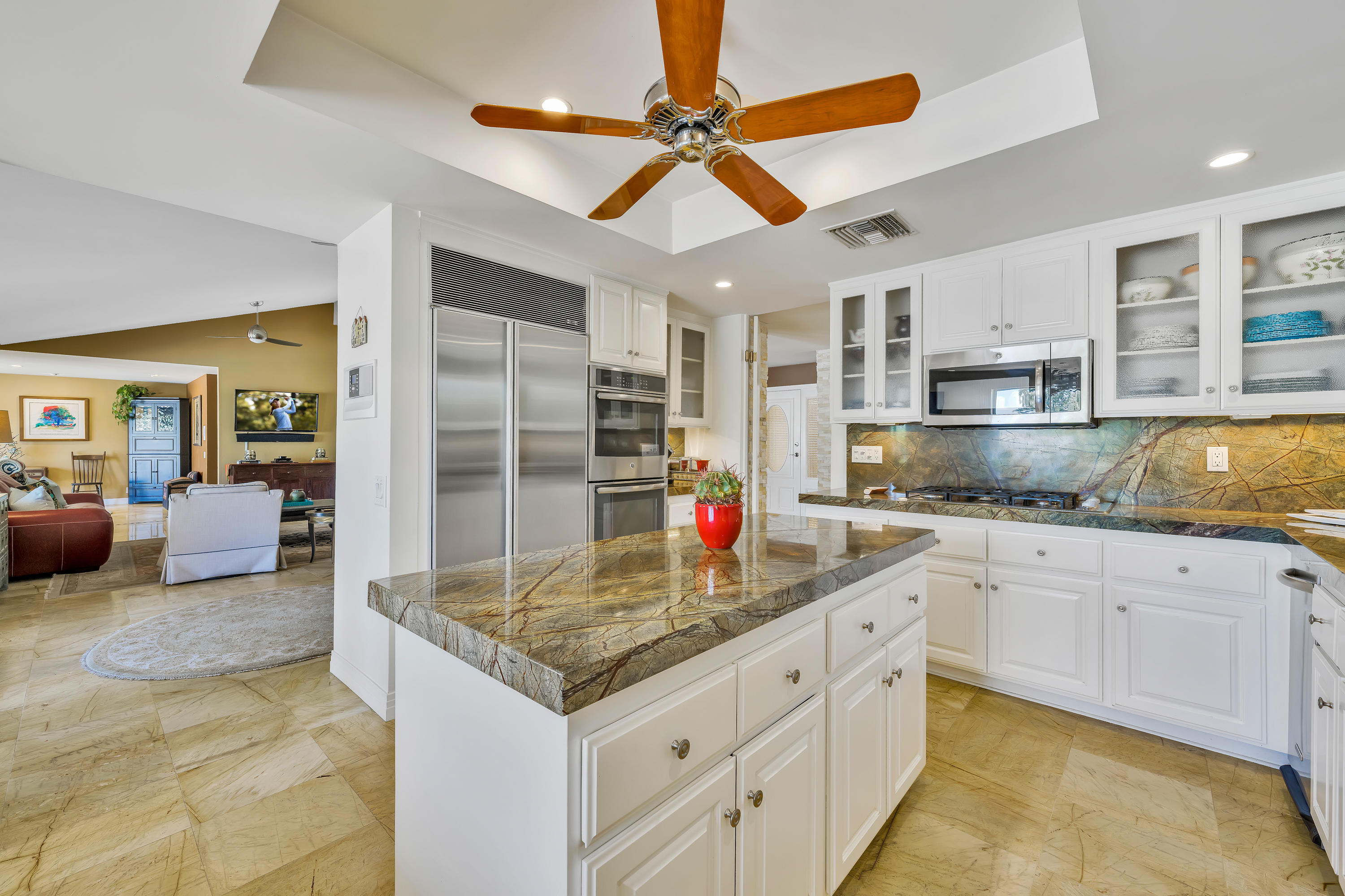 73005 Haystack Road Palm Desert, CA 92260 - Photo 20 of 45 a kitchen with kitchen island granite countertop a sink cabinets and stainless steel appliances