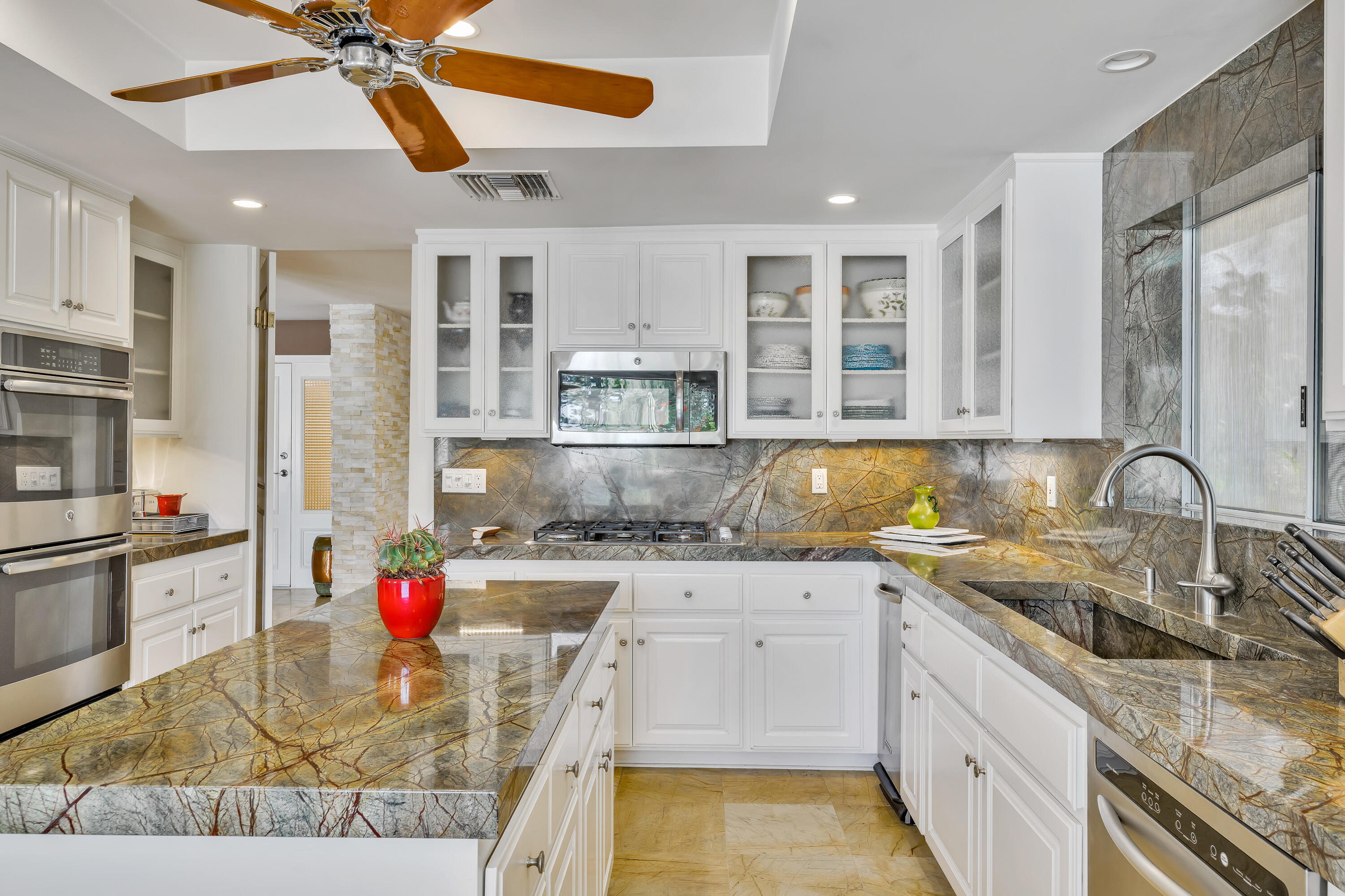73005 Haystack Road Palm Desert, CA 92260 - Photo 22 of 45 a kitchen with a sink dishwasher and white cabinets with wooden floor