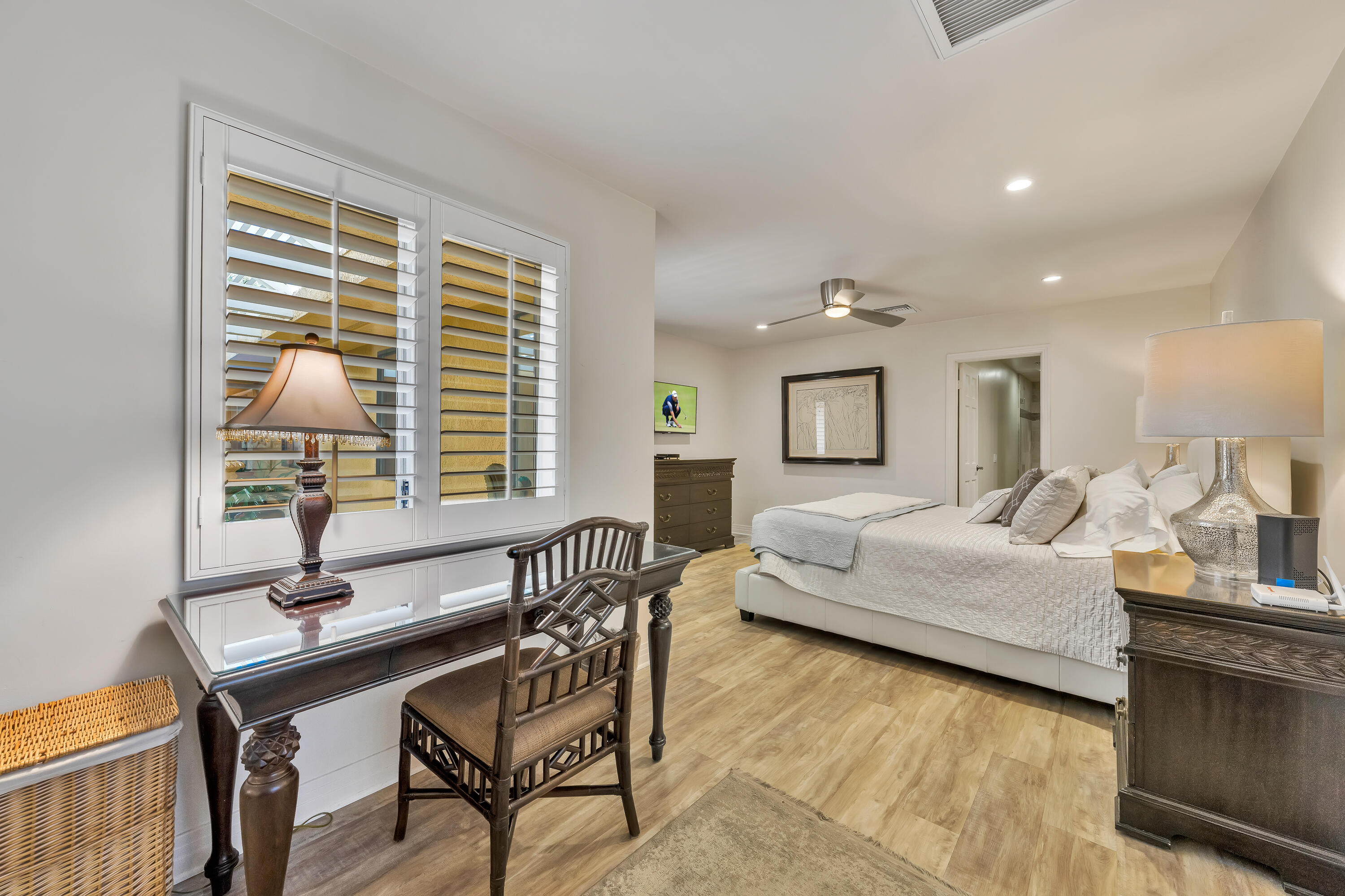 73005 Haystack Road Palm Desert, CA 92260 - Photo 27 of 45 a bedroom with a bed a desk and chair with wooden floor