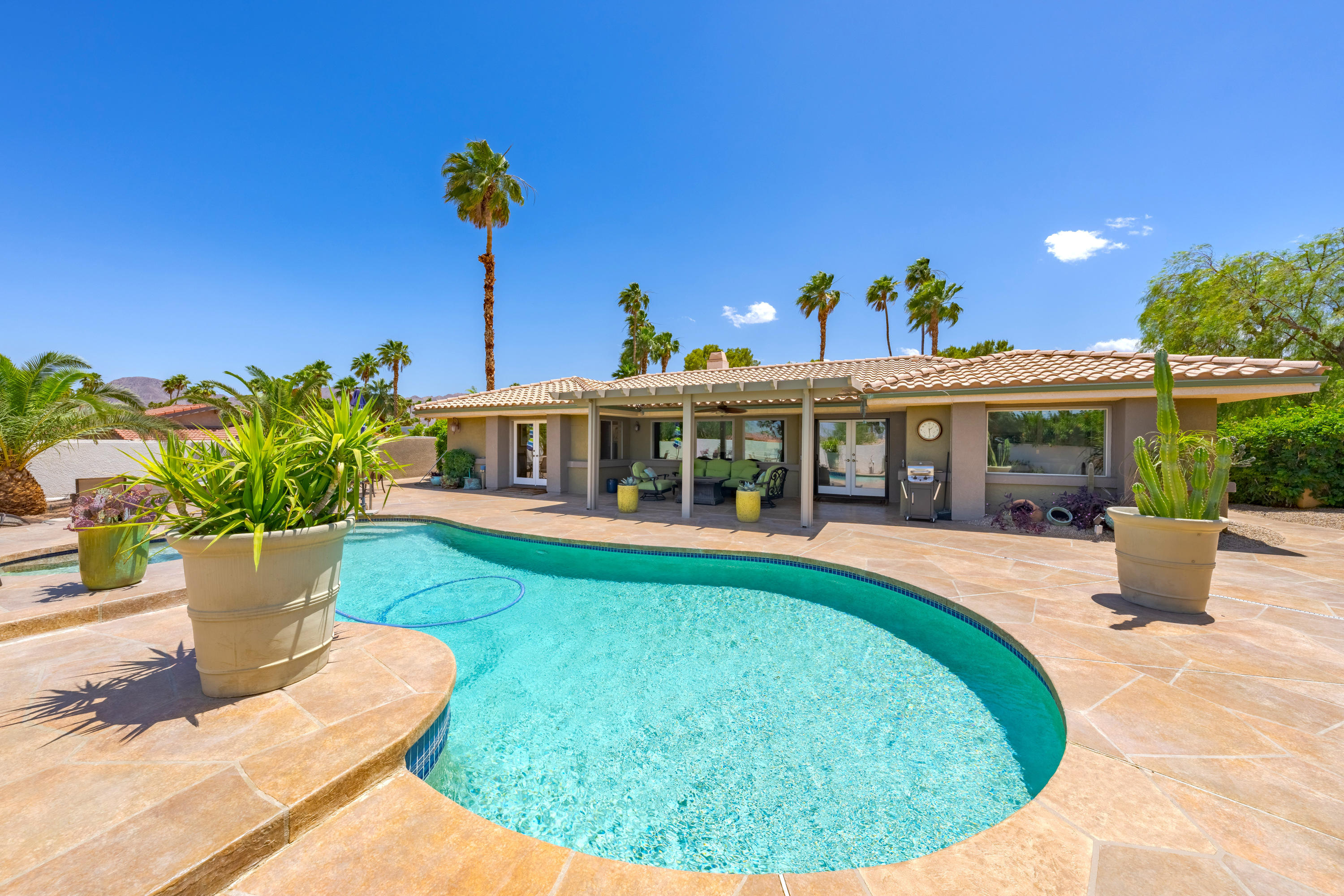 73005 Haystack Road Palm Desert, CA 92260 - Photo 42 of 45 a view of a house with pool fire pit a patio and a garden