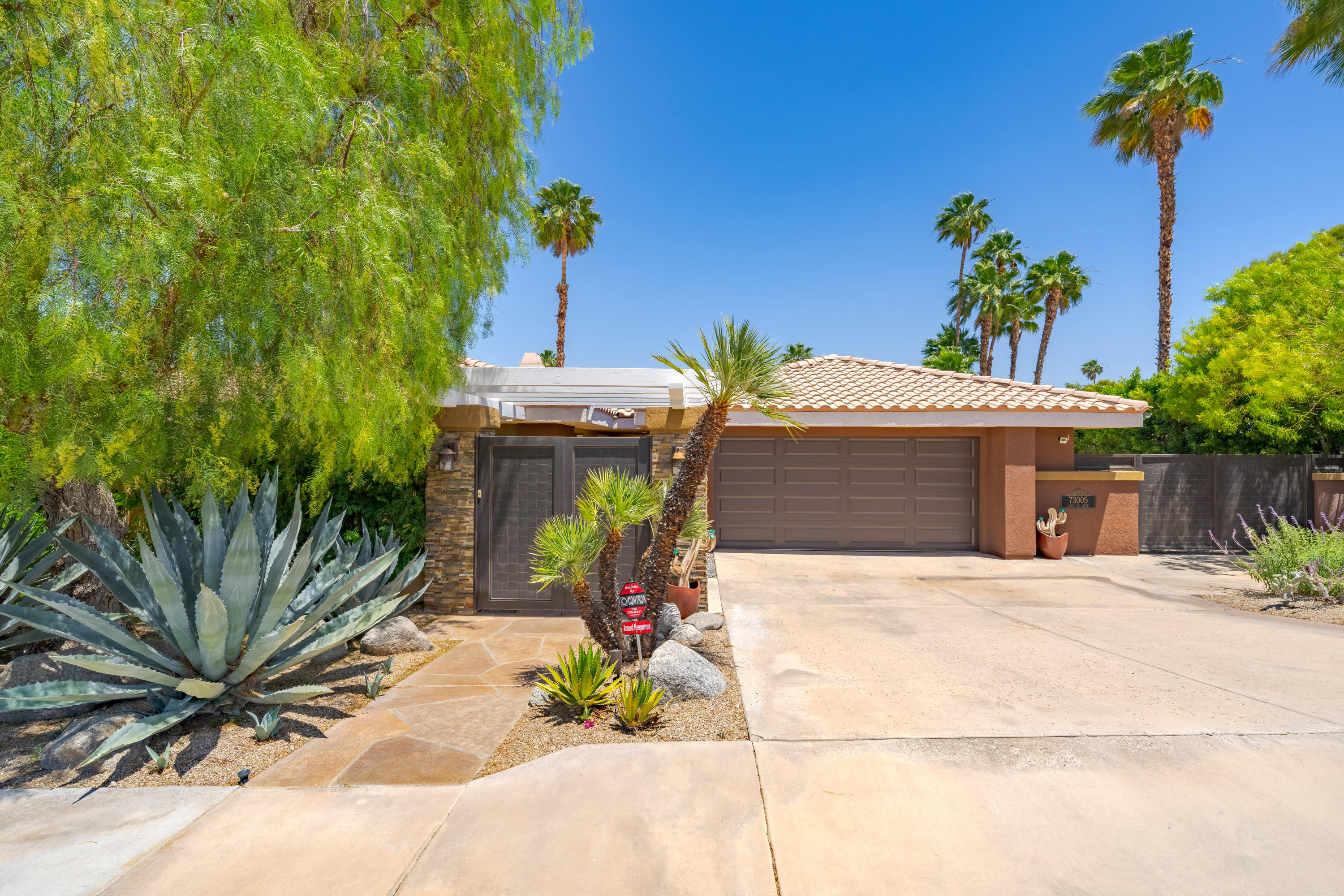 73005 Haystack Road Palm Desert, CA 92260 - Photo 6 of 45 a front view of a house with a yard and outdoor seating