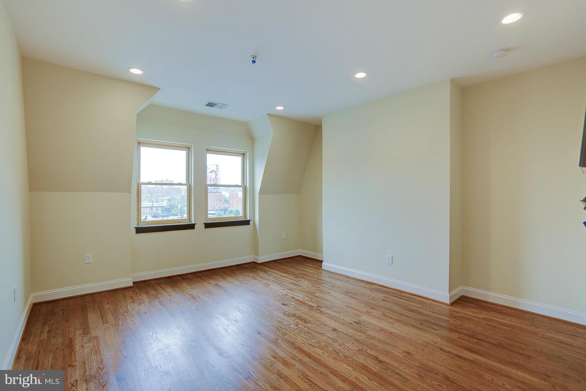 1609 St Paul Street Baltimore, MD 21202 - Photo 2 of 6 a view of an empty room with wooden floor and a window