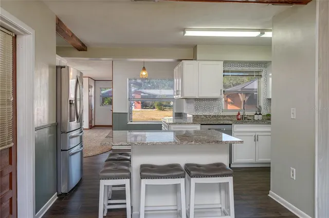 a kitchen with kitchen island a counter top space a sink stainless steel appliances and cabinets
