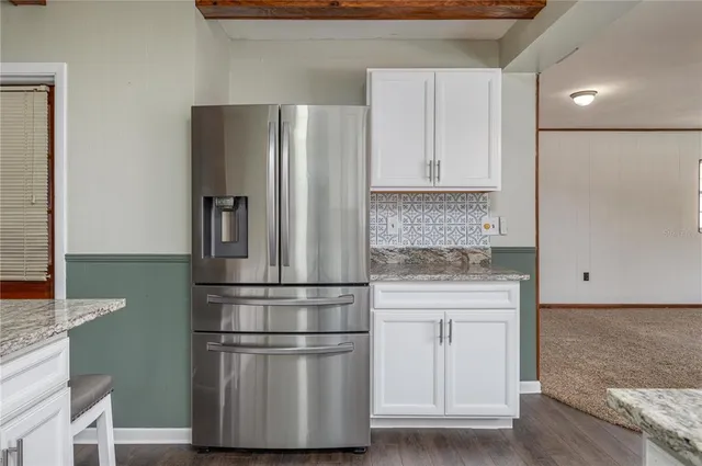 a kitchen with stainless steel appliances granite countertop a refrigerator and a stove top oven
