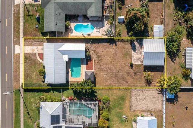 an aerial view of a house with a yard swimming pool and outdoor seating