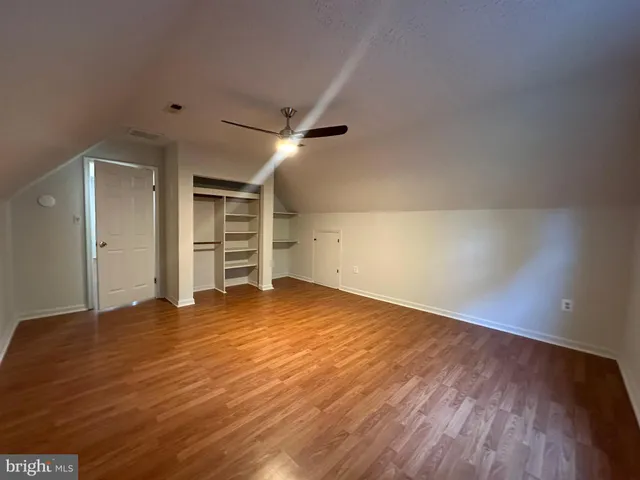 a view of empty room with wooden floor and window