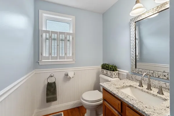 a bathroom with a granite countertop toilet sink and mirror