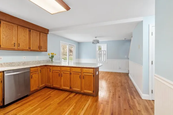 a kitchen with granite countertop wooden floors and white stainless steel appliances