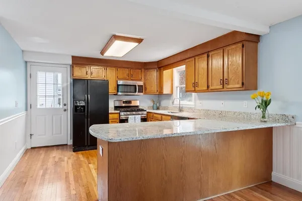 a kitchen with stainless steel appliances granite countertop a refrigerator a sink a stove and island