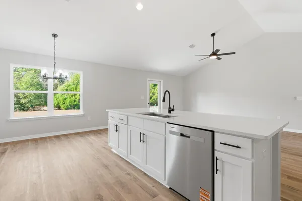 a kitchen with a sink and wooden floor