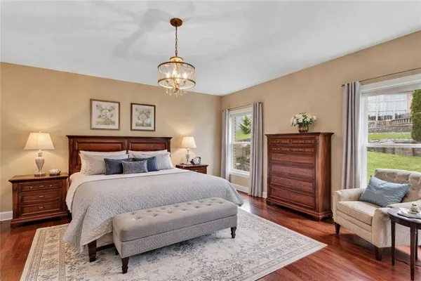 a bedroom with a bed chandelier and a window