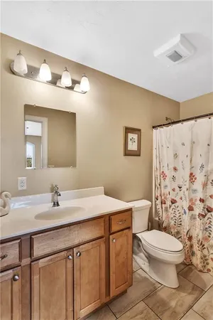 a bathroom with a granite countertop sink mirror vanity and toilet