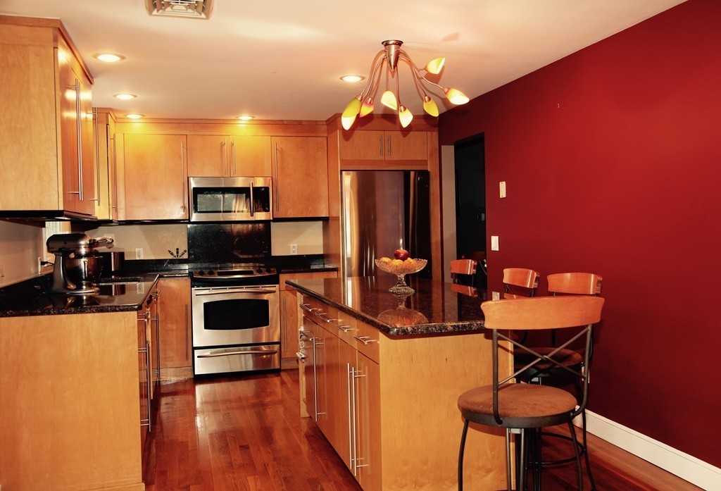 155 Noanett Road Needham, MA 02494 - Photo 1 of 18 a kitchen with stainless steel appliances a dining table and chairs in it