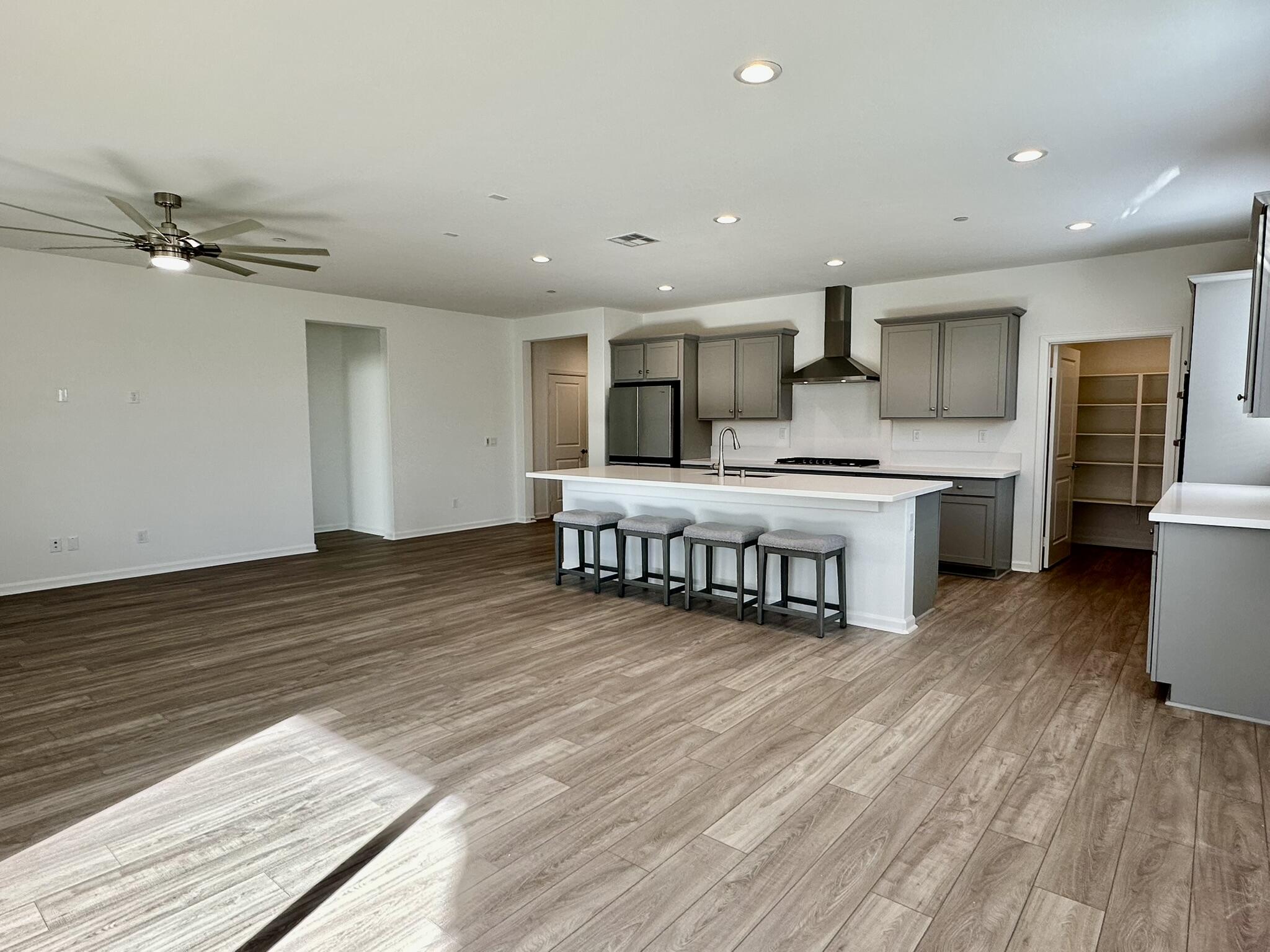 78879 Fortuna Place Palm Desert, CA 92211 - Photo 4 of 25 a large kitchen with stainless steel appliances a large counter top a chandelier and a view of living room